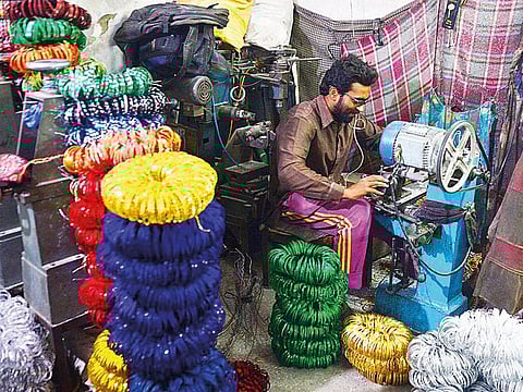 A worker is busy in preparing of metal bangles in a local factory in Badami Bagh area as for upcoming Eid-ul Fitr. 