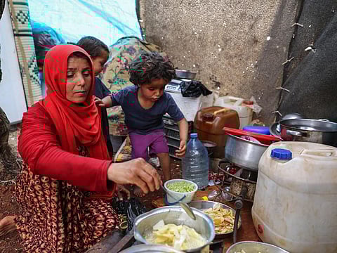 Displaced Syrian mother Mona Mutayr prepares Iftar meal in a field near a camp for displaced people at the village of Atme, in the jihadist-held northern Idlib province on May 23, 2019, during the Muslim holy fasting month of Ramadan. 