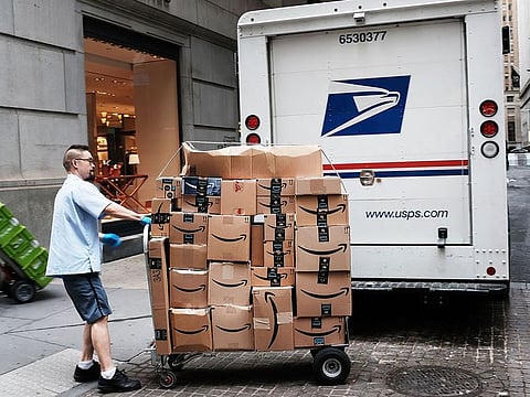 A US Postal worker delivers Amazon boxes outside of the New York Stock Exchange in New York City.  