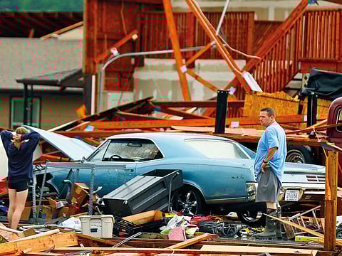 A man and woman inspect the damage to their home and classic cars after being hit by a tornado on Tuesday, May 28, 2019, in a neighborhood south of Lawrence, Kansas, near US-59 highway and N. 1000 Road.