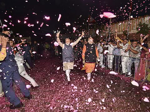 Bhartiya Janata Party workers welcome Prime Minister Narendra Modi (left) and BJP President Amit, who arrive at the party headquarters to celebrate the party's victory in the 2019 Lok Sabha elections, in New Delhi, on May 23, 2019.