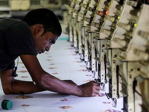 A worker adjusts the thread on an embroidery machine at a workshop in Mumbai, India, May 31, 2019. 