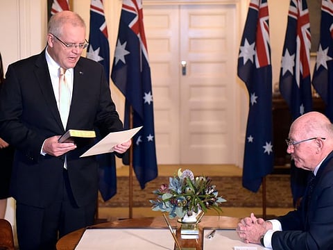 New Australian Prime Minister Scott Morrison takes oath of his office during a ceremony in front of Australia's Governor General Peter Cosgrove (R) at Government House in Canberra on May 29, 2019.