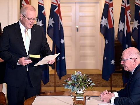 New Australian Prime Minister Scott Morrison takes oath of his office during a ceremony in front of Australia's Governor General Peter Cosgrove (R) at Government House in Canberra on May 29, 2019.