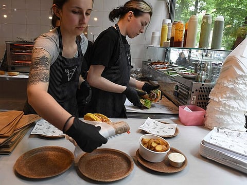 Women working in one of Warsaw's vegan restaurants serve meals on wheat bran plates produced at the Biotrem factory in Zambrow, Poland.