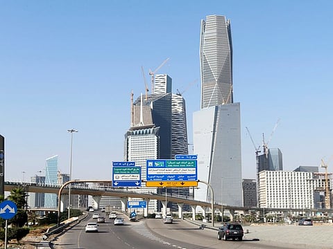 Cars drive past the King Abdullah Financial District in Riyadh, Saudi Arabia.