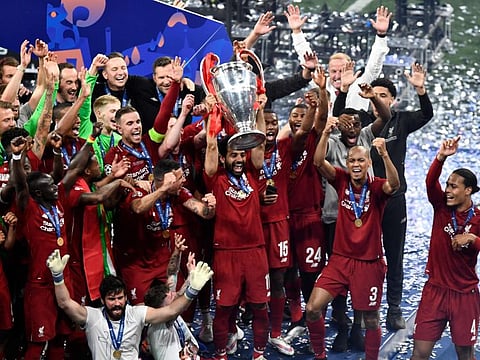 Liverpool's Egyptian midfielder Mohamed Salah (C) celebrates with the trophy after winning the UEFA Champions League final football match between Liverpool and Tottenham Hotspur at the Wanda Metropolitan Stadium in Madrid on June 1, 2019. / AFP / OSCAR DEL POZO