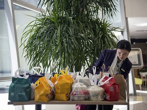 At rush hour, delivery services leave takeout orders in the lobbies of office buildings to save time, in Beijing