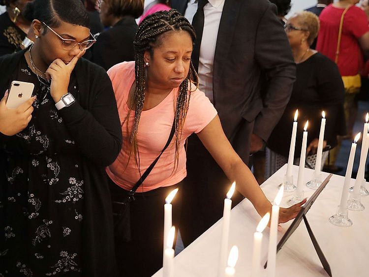 mass shooting surrounded by 12 candles during a memorial service at Piney Grove Baptist Church 