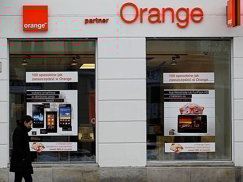 A woman passes in front of an Orange store in Warsaw February 12, 2013. 