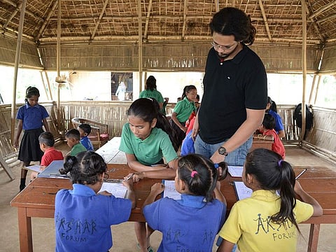 Founder of the school, Mazin Mukhtar (C standing), interacts with students during a class at the Akshar Forum school in Pamohi on the outskirts of Guwahati.