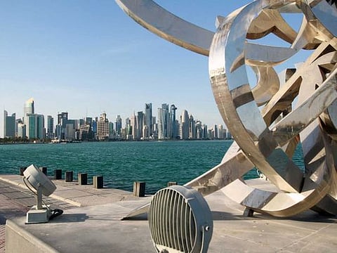 Buildings are seen from across the water in Doha