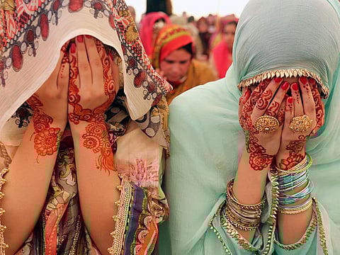 Women pray on the Eid Al Fitr in Lahore, Pakistan, on Wednesday, June 5, 2019. 