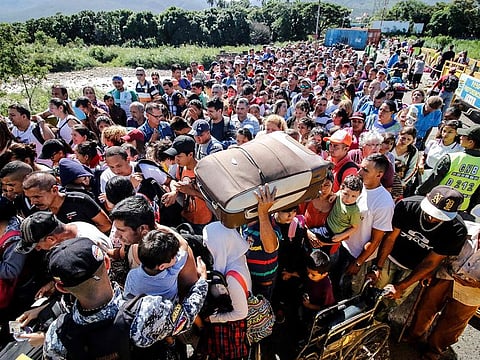 People queue to cross the Simon Bolivar international bridge from San Antonio del Tachira in Venezuela to Cucuta, in Colombia, to buy goods due to supplies shortage in their country, on June 8, 2019.