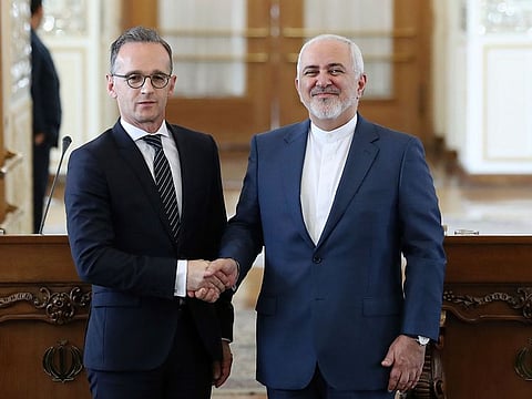 Iranian Foreign Minister Mohammad Javad Zarif, right, and his German counterpart Heiko Maas shake hands as they pose for photos at the end of their press conference in Tehran, Iran.