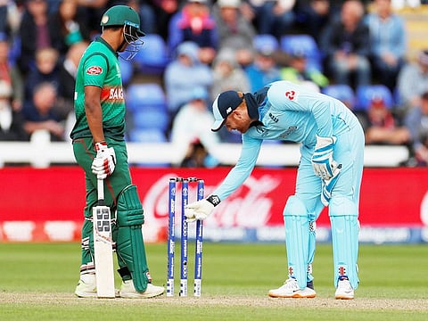 England's Jonny Bairstow inspects the stumps after the ball hit them and the bails did not fall as Bangladesh's Mohammad Saifuddin looks on during their World Cup match at Cardiff Wales Stadium. 