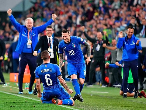 Italy's Marco Verratti, left, celebrates with his teammate Federico Bernardeschi after scoring his side's second.
