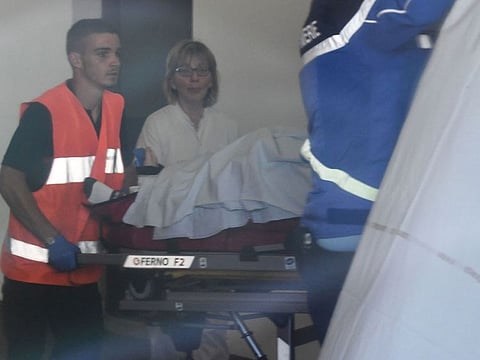 Rescue workers are seen through a window as they transport Christopher Froome in a stretcher upon arrival at the Centre Hospitalier after he fell on a training run in Roanne on June 12, 2019. 