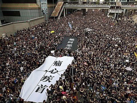 Protesters carry a huge banner reading "Our hearts are torn to pieces. Withdraw the monstrous bill" as they march on the streets against an extradition bill in Hong Kong.