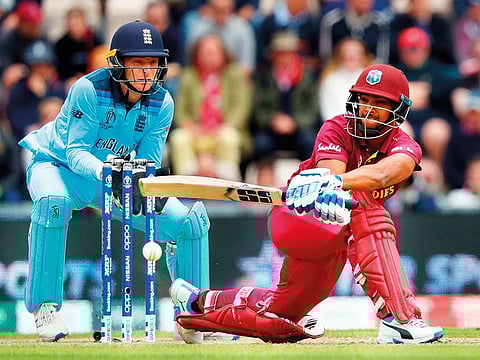 West Indies' Nicholas Pooran (R) sweeps the ball past England's wicketkeeper Jos Buttler during the 2019 Cricket World Cup group stage match between England and West Indies at the Rose Bowl in Southampton, southern England, on June 14, 2019.