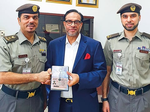 Mohammad Mahtabur Rahman receives his Gold Card from Col Ali Mohammad Al Hammadi and Lt Abu Bakr Ahmad Al Ali at the GDRFA headquarters in Dubai.