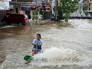 Indonesian teens wakeboard waterlogged streets to protest floods