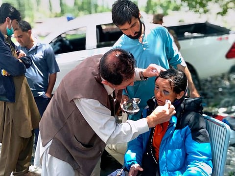 Mountaineers receive initial treatment following her rescue, at a helipad in the town of Imit, Ghizer district of Gilgit Balistan region, Pakistan