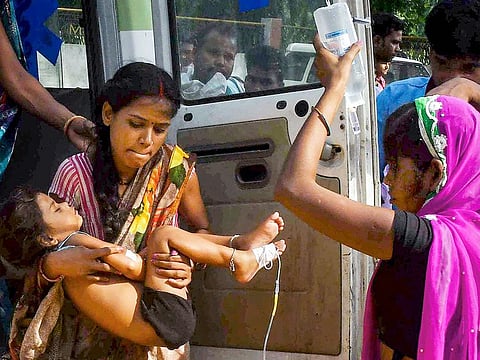 A woman carrying a child showing symptoms of Acute Encephalitis Syndrome (AES) arrives at Shri Krishna Medical College and hospital for treatment, in Muzaffarpur. 
