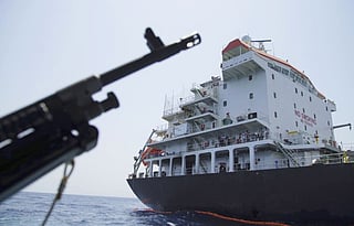 Sailors stand on deck above a hole the U.S. Navy says was made by a limpet mine on  the damaged Panama-flagged, Japanese owned oil tanker Kokuka Courageous, anchored off Fujairah, United Arab Emirates, during a trip organized by the Navy for journalists, Wednesday, June 19, 2019.  