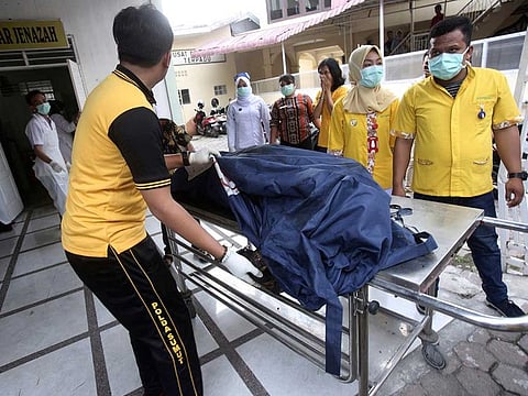 Paramedics put body bags containing the remains of the victims of a fire that razed through a match factory at a hospital in Medan, North Sumatra, Indonesia, Friday, June 21, 2019.