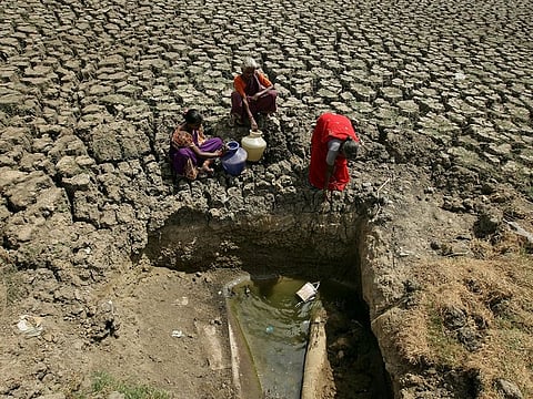 Women fetch water from an opening made by residents at a dried-up lake in Chennai, India, June 11, 2019.