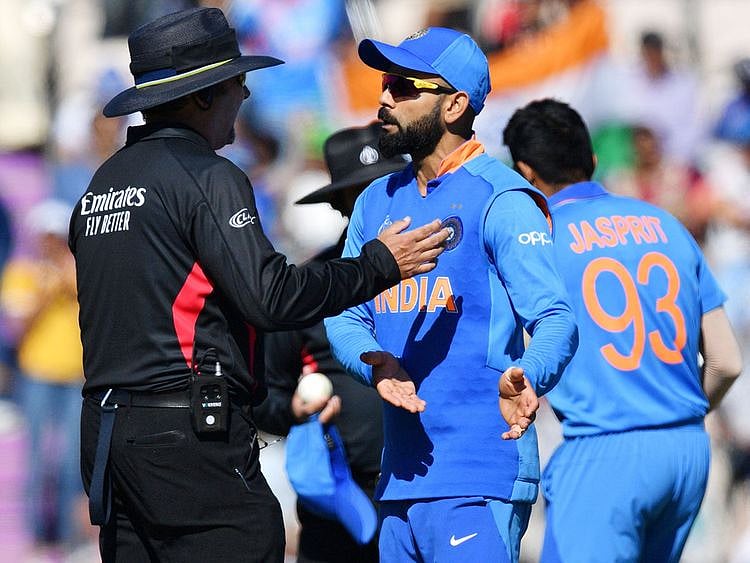 India's captain Virat Kohli (C) speaks with the umpire