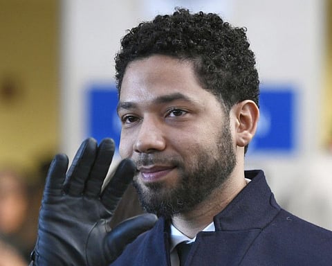 FILE - In this March 26, 2019, file photo, actor Jussie Smollett smiles and waves to supporters before leaving Cook County Court after his charges were dropped in Chicago. A judge has appointed a special prosecutor to investigate the decision by Cook County prosecutors do dismiss all charges against Smollett. On Friday, June 21, 2019, Cook County Judge Michael Toomin suggested Cook County State's Attorney Kim Foxx mishandled the case by recusing herself and then ordering a top assistant to handle the case. (AP Photo/Paul Beaty, File)