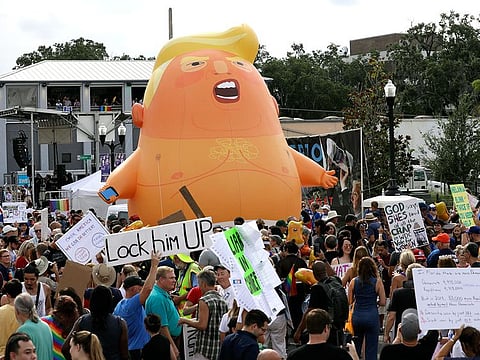 An inflatable Baby Trump balloon towers over protestors during a rally.