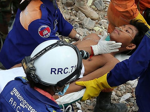 A survivor is carried out of the rubble from a collapsed building in Sihanoukville on June 24, 2019. Two men were pulled alive from the rubble of a collapsed Cambodian building on June 24, according to an AFP reporter at the scene, more than two days after the construction site accident that left at least 25 dead.