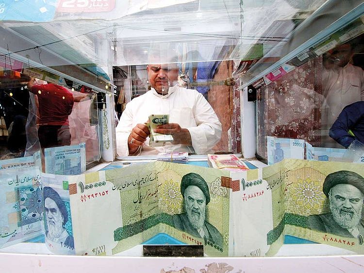 FILE: A man counts Iranian rials 012