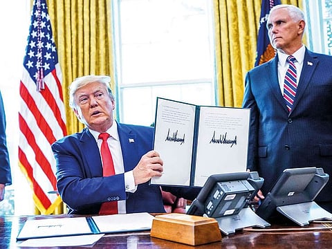 Trump, flanked by Mike Pence (right) and Steven Mnuchin at the White House signs  ‘hard-hitting sanctions’ on Iran’s supreme leader.