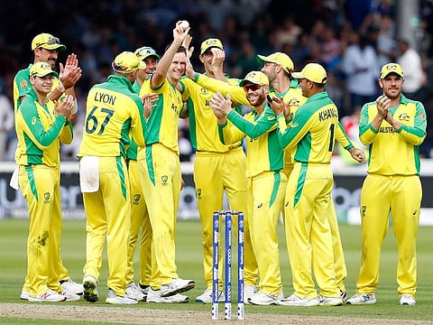 Australia's Jason Behrendorff, centre, holds up the ball as he celebrates with teammates after taking the wicket of England's Jofra Archer during their match at Lord's cricket ground in London. 