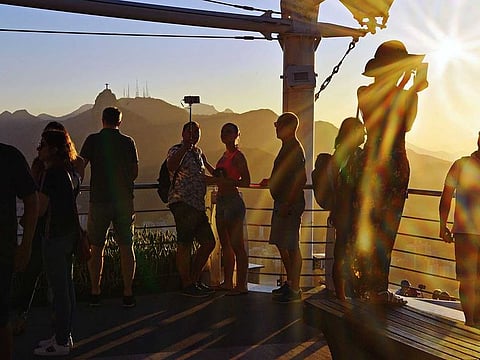 Tourists take selfies at Sugarloaf Hill.
