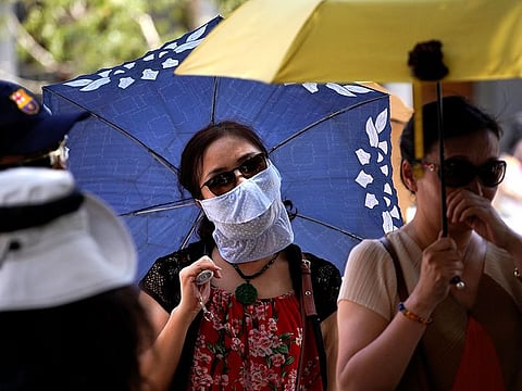 Asian tourists shelter under umbrellas as a heatwave hits Europe in Toledo, Spain.