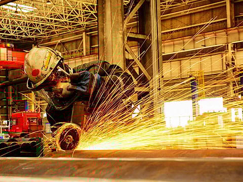 This file picture taken on February 28, 2019 shows a worker polishing an oil pipe at a factory in Qingdao in China's eastern Shandong province. 
