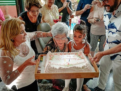 Cuban Delia Barrios, 102, blows out the cake candles during her birthday in Havana, on May 18, 2019
