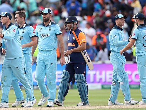 India's MS Dhoni, third right, watches as England players celebrate after their win at Edgbaston in Birmingham.