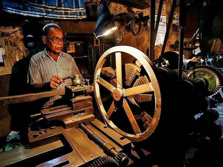 A worker operates a lathe