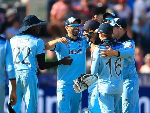 England's Mark Wood, centre, and teammates celebrate after winning the World Cup match against New Zealand in Chester-le-Street. 