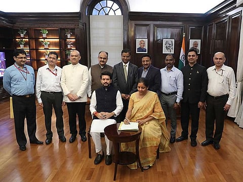 Indian Finance Minister Nirmala Sitharaman, seated right, signs the Indian federal budget after giving final touches, as Indian junior Finance Minister Anurag Thakur, seated left, watches along with finance budget team at her office in New Delhi, on Thursday, July 4, 2019.  