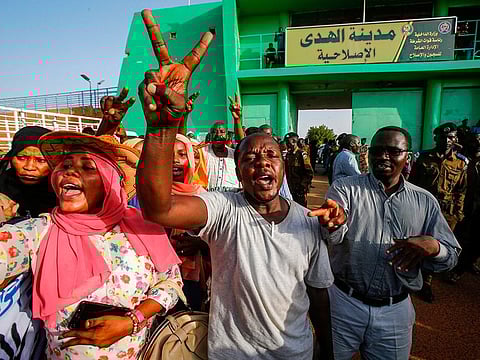 A Sudanese man flashes the victory gesture as people gather outside al-Huda prison in the capital Khartoum's twin city of Omdurman on July 4, 2019, during a ceremony marking the release of 235 members of a faction of the Sudan Liberation Army, which has fought government forces in war-torn Darfur. 