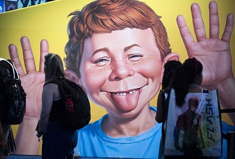 In this July 20, 2017 file photo the face of Alfred E. Neuman is framed by attendees at the DC booth during the first day of Comic-Con International at the San Diego Convention Center in San Diego, California.