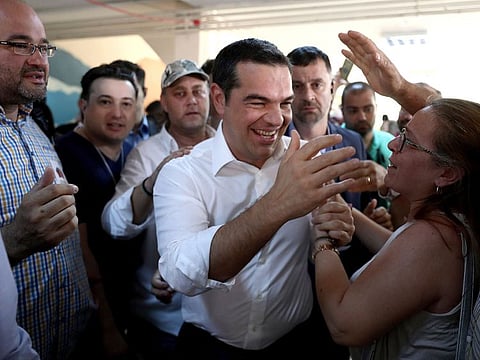 Greek Prime Minister and Syriza party leader Alexis Tsipras greets supporters at a polling station in Athens.