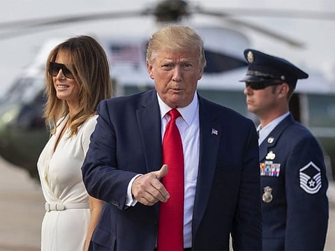 President Donald Trump with first lady Melania Trump gestures upon arrival at Andrews Air Force Base, Md., Sunday, July 7, 2019. 